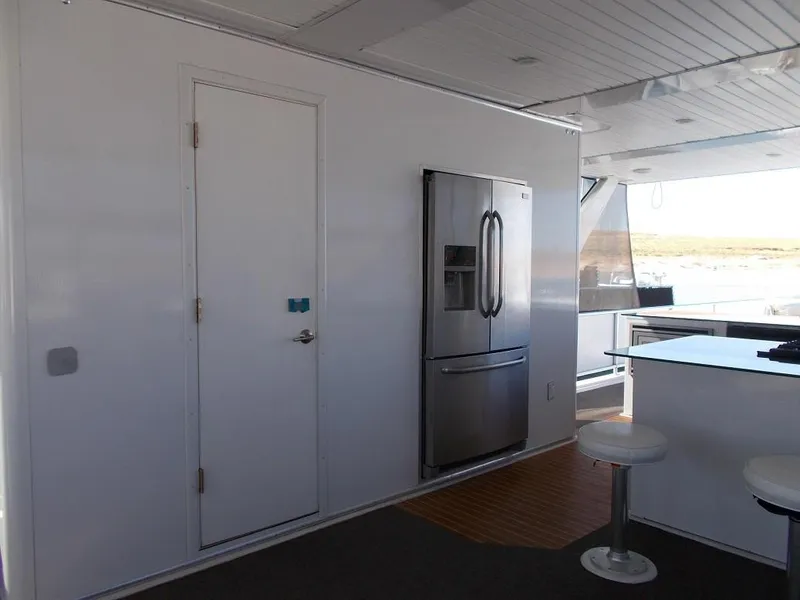 Slide: The Image of Modern kitchen area on 2015 Bravada Intrepid Share #10 houseboat with stainless steel fridge. - 4