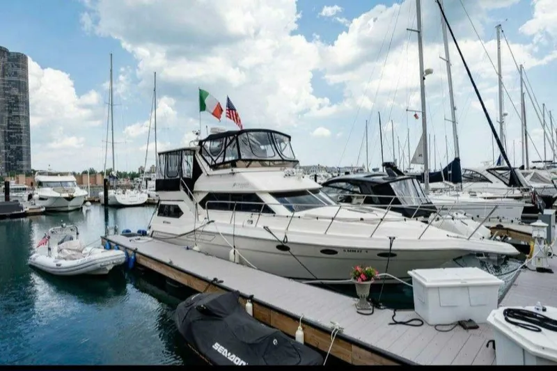 Slide: The Image of 1991 Cruisers Yachts 3850 Aft Cabin docked at marina under cloudy sky. - 1