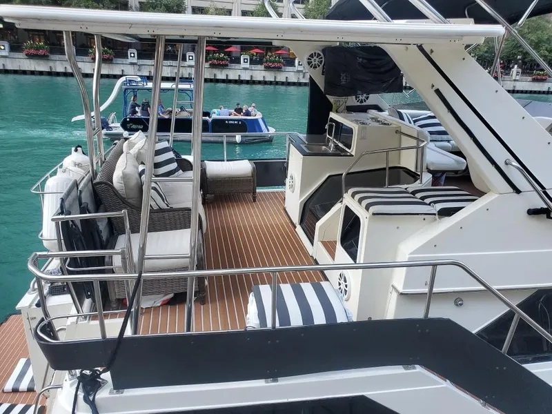 Slide: The Image of 1991 Cruisers Yachts 3850 Aft Cabin on water with striped cushions. - 13