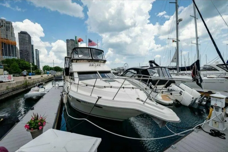 Slide: The Image of 1991 Cruisers Yachts 3850 Aft Cabin docked at a marina with city skyline. - 2