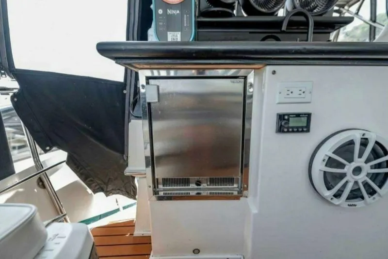 Slide: The Image of 1991 Cruisers Yachts 3850 Aft Cabin interior with fridge, speaker, and control panel. - 37