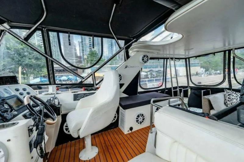 Slide: The Image of 1991 Cruisers Yachts 3850 Aft Cabin interior with helm, seating, and cityscape view. - 41
