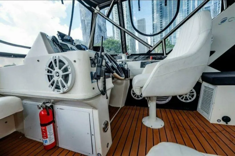 Slide: The Image of 1991 Cruisers Yachts 3850 Aft Cabin helm with white seating and wood flooring. - 42