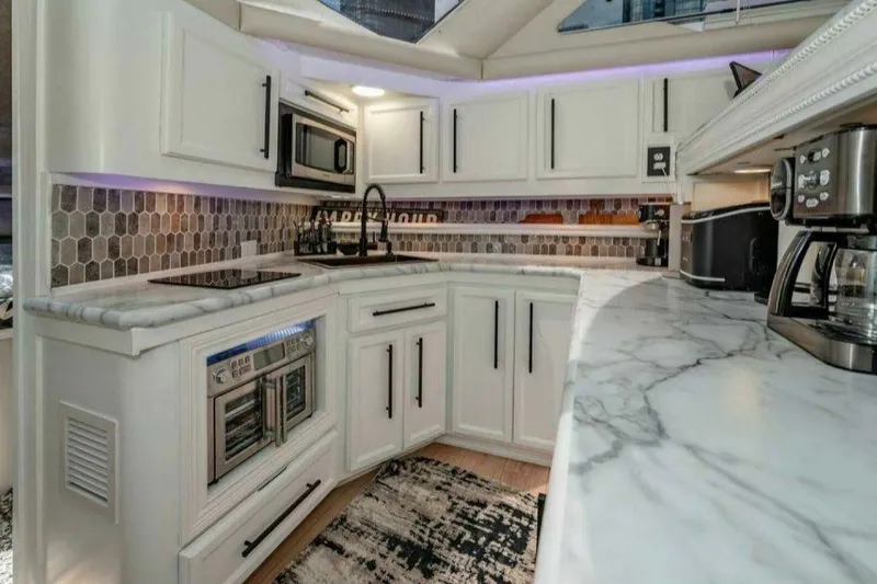 Slide: The Image of Luxurious kitchen in 1991 Cruisers Yachts 3850 Aft Cabin with modern appliances and marble countertops. - 57