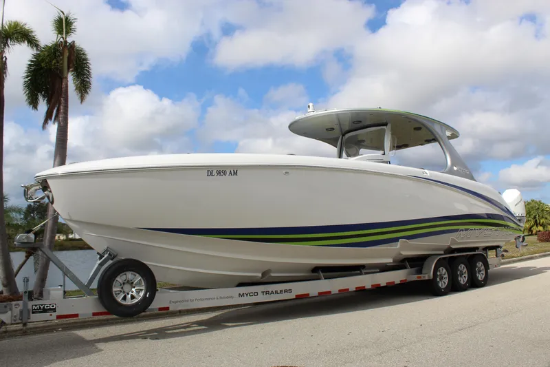 Slide: The Image of 2020 Mystic Powerboats M4200 on trailer, sleek design with blue and green accents. - 0