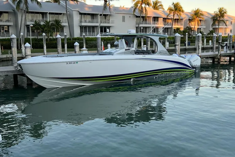 Slide: The Image of 2020 Mystic Powerboats M4200 docked in a marina, reflecting on calm water. - 57