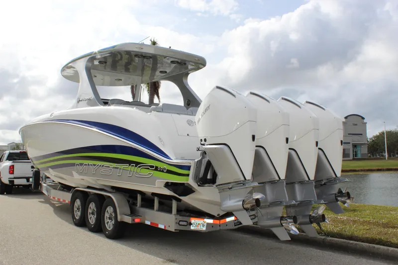 Slide: The Image of 2020 Mystic Powerboats M4200 with quad engines on a trailer by a lake. - 9