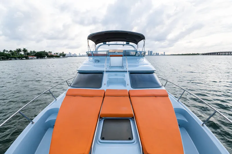 Slide: The Image of 2003 Sea Ray Express Bridge yacht with orange sunbeds on a calm water backdrop. - 12