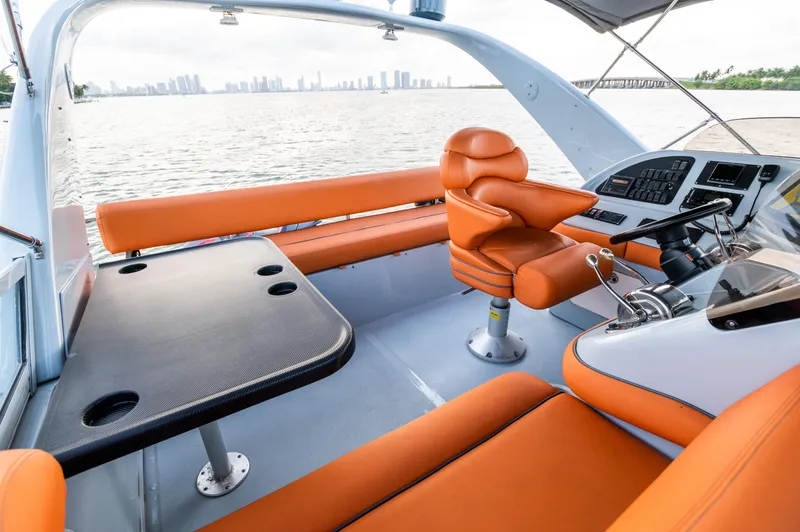 Slide: The Image of 2003 Sea Ray Express Bridge interior with orange seating, overlooking water and city skyline. - 13