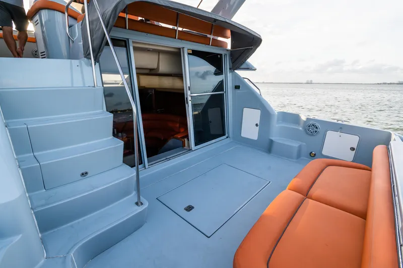 Slide: The Image of 2003 Sea Ray Express Bridge yacht with orange seating and sliding glass doors. - 4