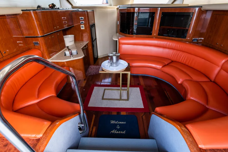 Slide: The Image of Luxurious 2003 Sea Ray Express Bridge interior with orange seating and elegant wood finishes. - 5