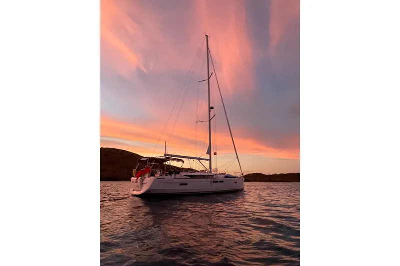 Slide: The Image of 2015 Jeanneau Sun Odyssey 469 sailboat at sunset on calm waters. - 10