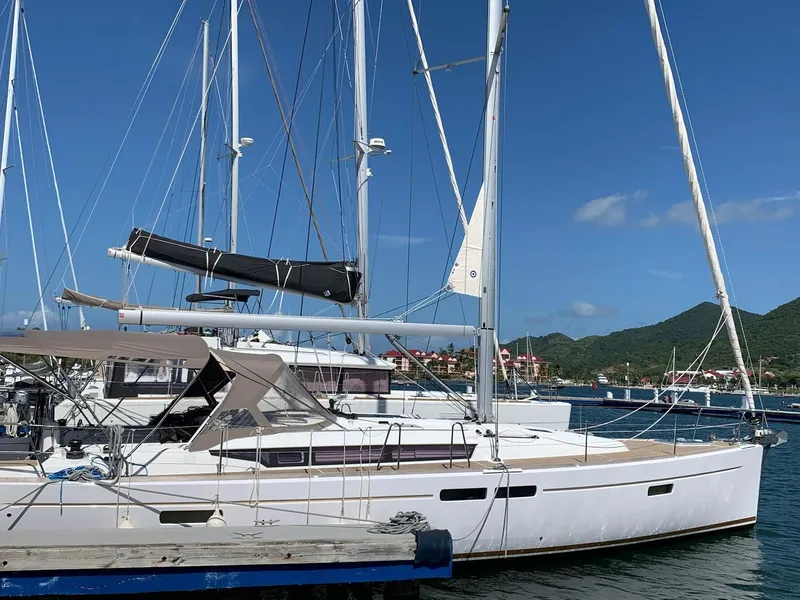 Slide: The Image of 2015 Jeanneau Sun Odyssey 469 sailboat docked in marina, clear blue sky background. - 13