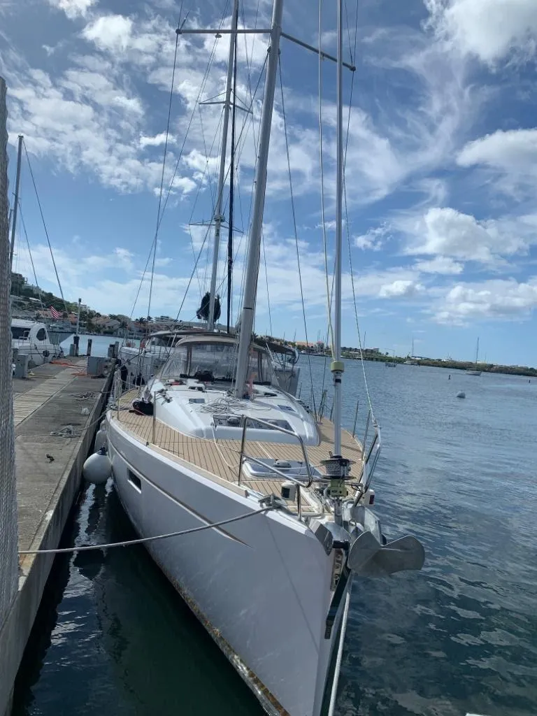 Slide: The Image of 2015 Jeanneau Sun Odyssey 469 sailboat docked in a marina under a partly cloudy sky. - 14