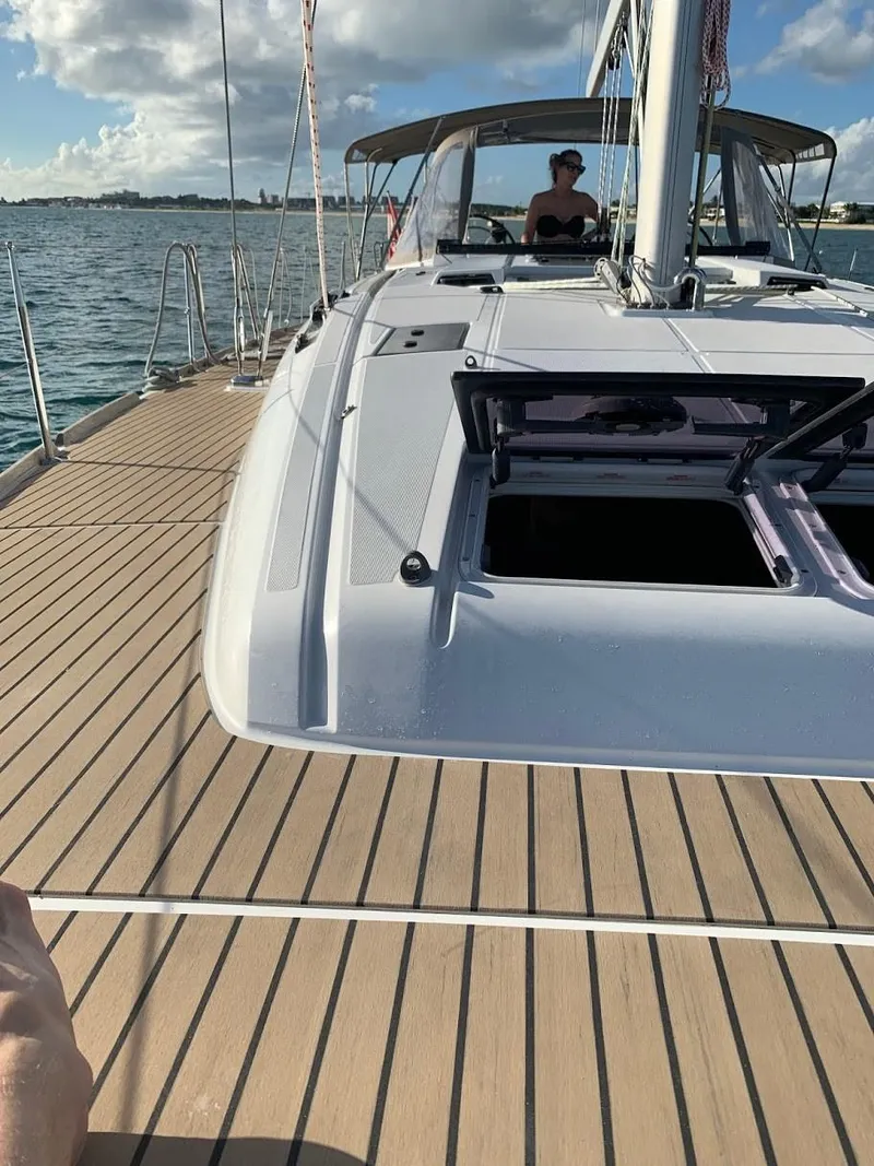 Slide: The Image of 2015 Jeanneau Sun Odyssey 469 sailboat on water, featuring spacious deck and open hatch. - 19