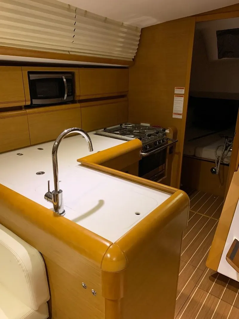 Slide: The Image of 2015 Jeanneau Sun Odyssey 469 yacht kitchen with modern amenities and wooden finish. - 42