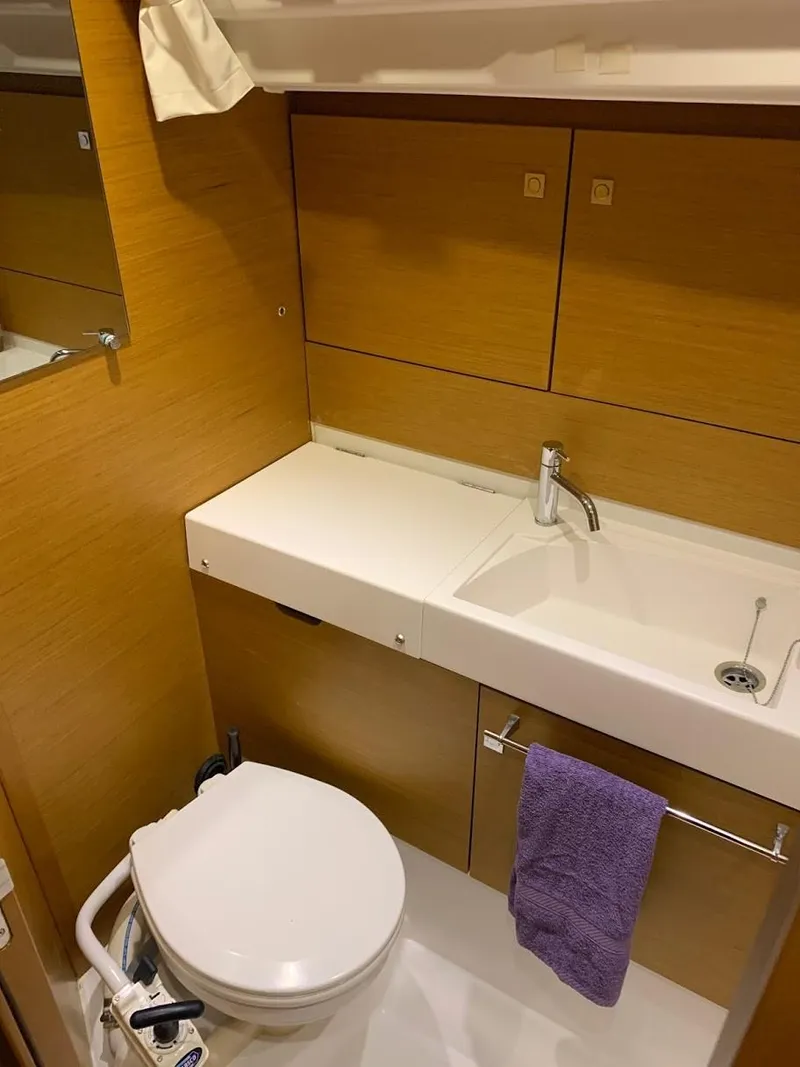 Slide: The Image of 2015 Jeanneau Sun Odyssey 469 bathroom with modern fixtures and wooden cabinetry. - 44