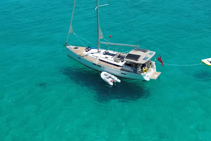 Slide: The Image of 2015 Jeanneau Sun Odyssey 469 sailboat anchored in clear turquoise water. - 5