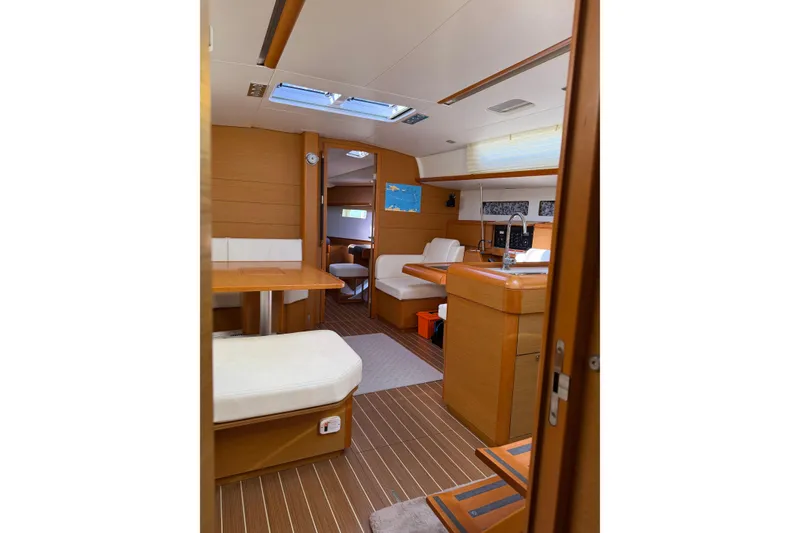 Slide: The Image of Interior of 2015 Jeanneau Sun Odyssey 469 sailboat, featuring modern wood finish and seating area. - 50