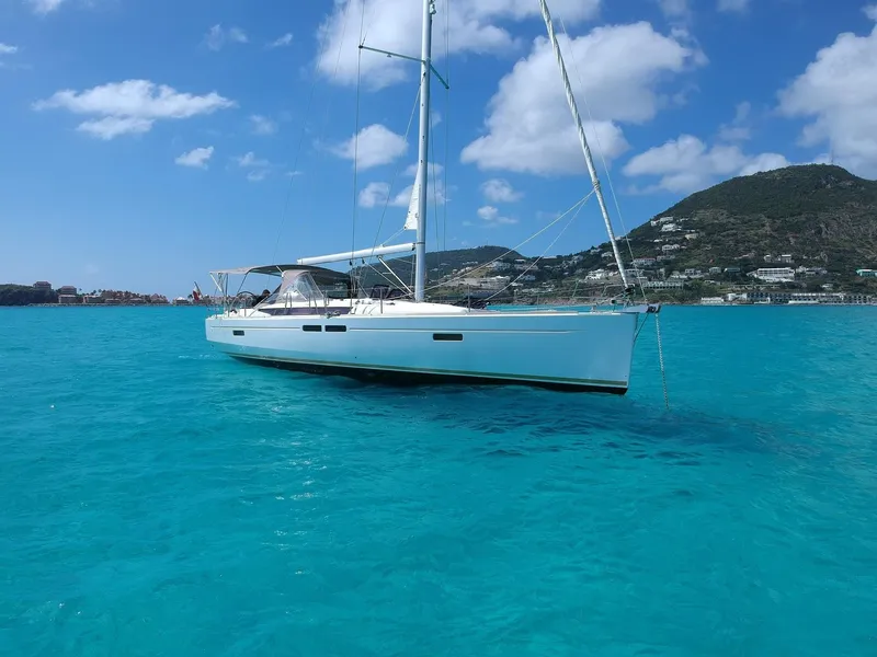 Slide: The Image of 2015 Jeanneau Sun Odyssey 469 sailboat on turquoise water with scenic mountain backdrop. - 6