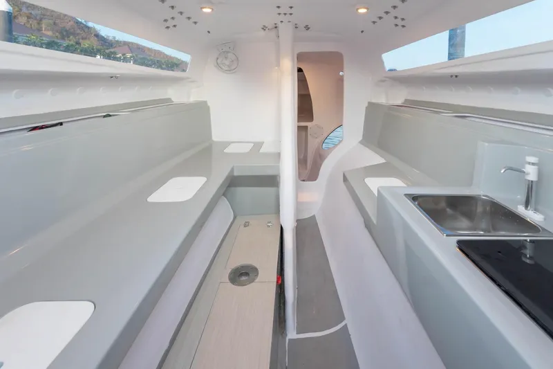 Slide: The Image of Interior of 2025 Corsair 880 sailboat, featuring modern seating and compact kitchen area. - 12