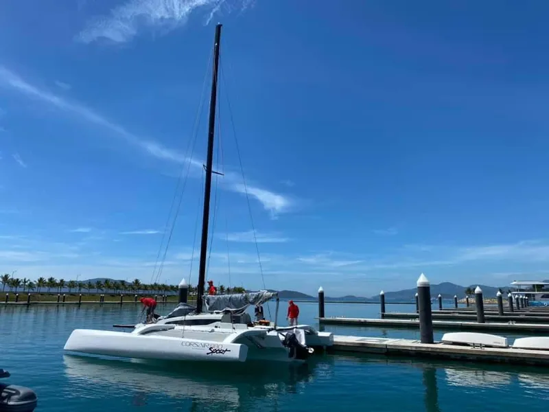 Slide: The Image of Sleek 2025 Corsair 880 sailboat docked in a serene marina under a clear blue sky. - 16