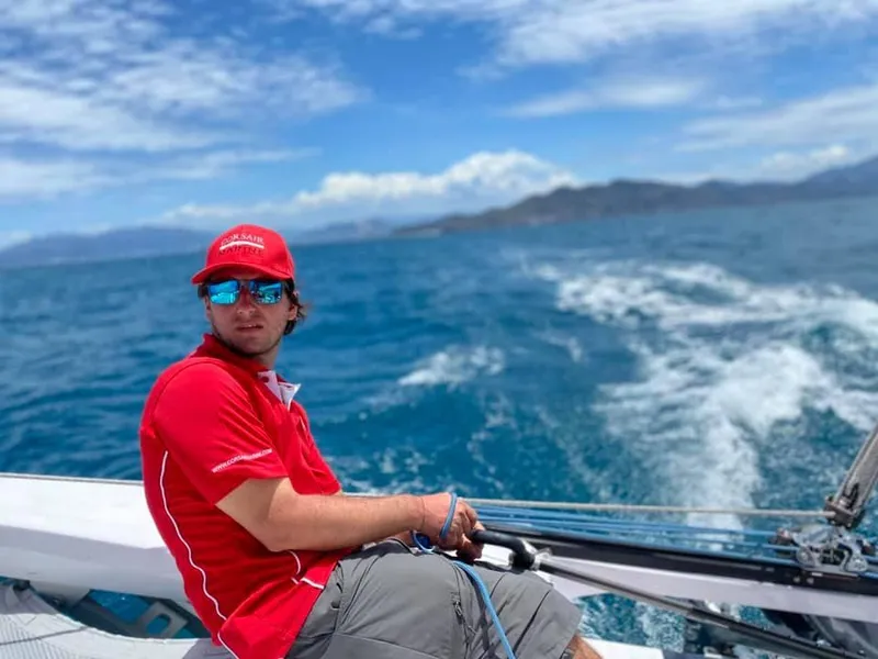 Slide: The Image of Man sailing Corsair 880 boat on open sea, wearing red shirt and cap, 2025 model. - 8