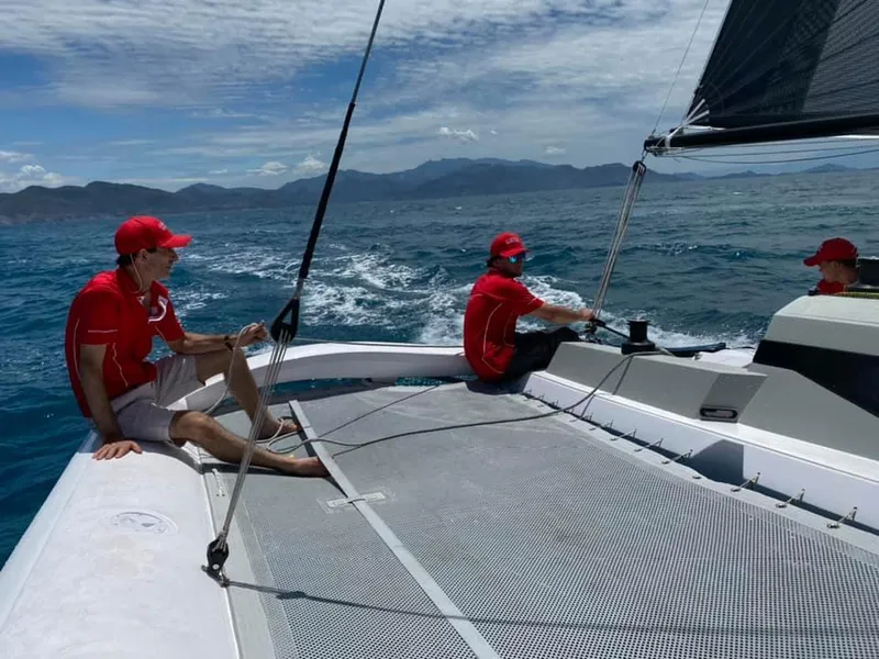Slide: The Image of Sailors on a 2025 Corsair 880 catamaran navigating the ocean under a clear sky. - 9