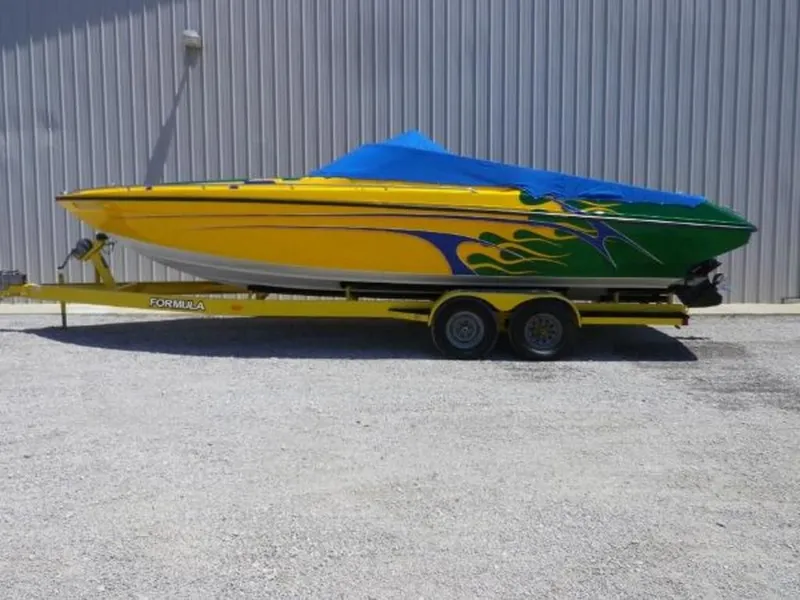 Slide: The Image of 1992 Formula Boats 27 model with vibrant yellow and green paint, on a trailer. - 1
