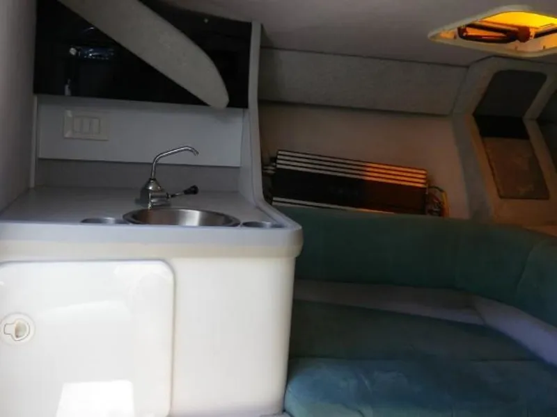 Slide: The Image of Interior of a 1992 Formula Boats 27, featuring a compact kitchenette and seating area. - 18
