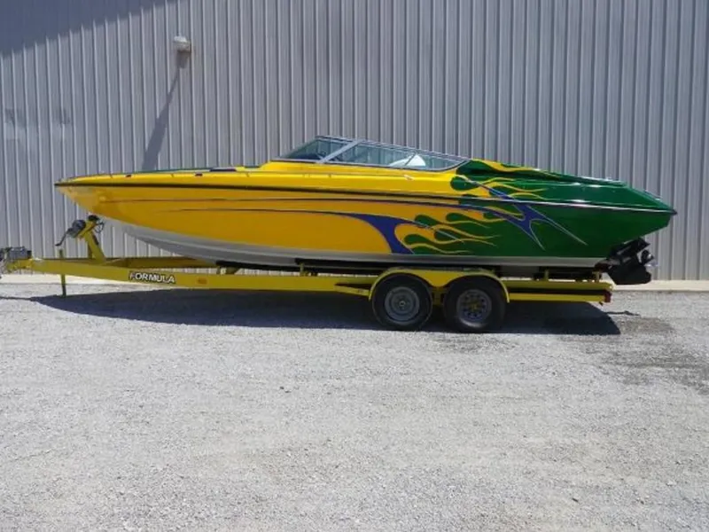 Slide: The Image of 1992 Formula Boats 27 model with vibrant yellow and green flame design on trailer. - 2