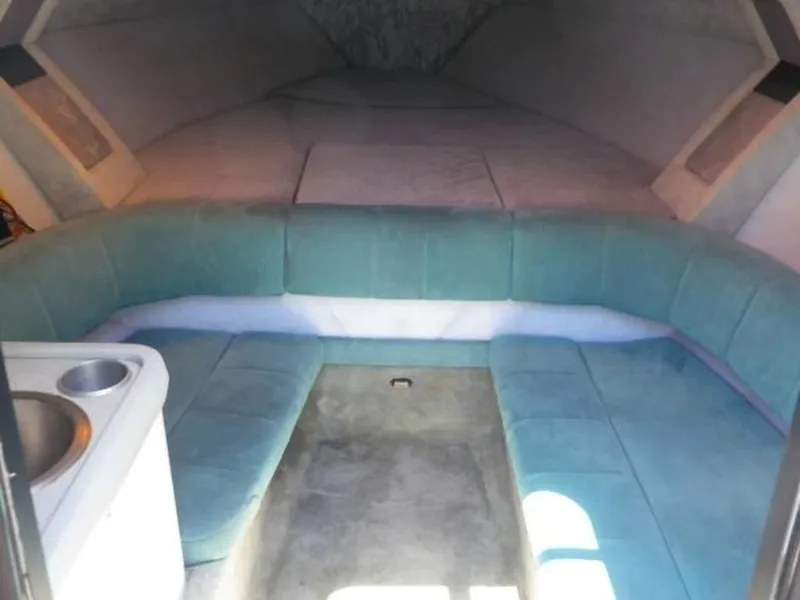 Slide: The Image of 1992 Formula Boats 27 interior cabin with teal seating and small sink. - 6