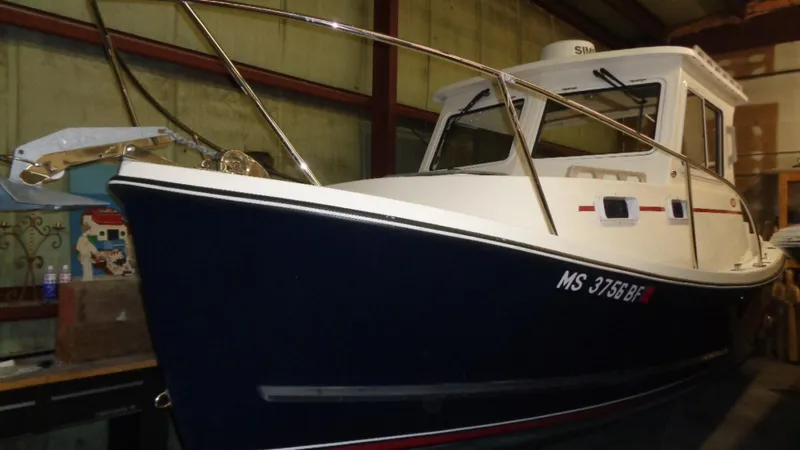 Slide: The Image of 2016 Eastern 248 Explorer boat in storage, blue hull, white cabin, side view. - 1