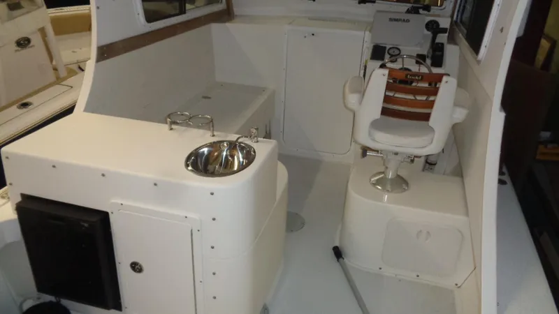 Slide: The Image of 2016 Eastern 248 Explorer boat interior with helm seat and sink. - 10