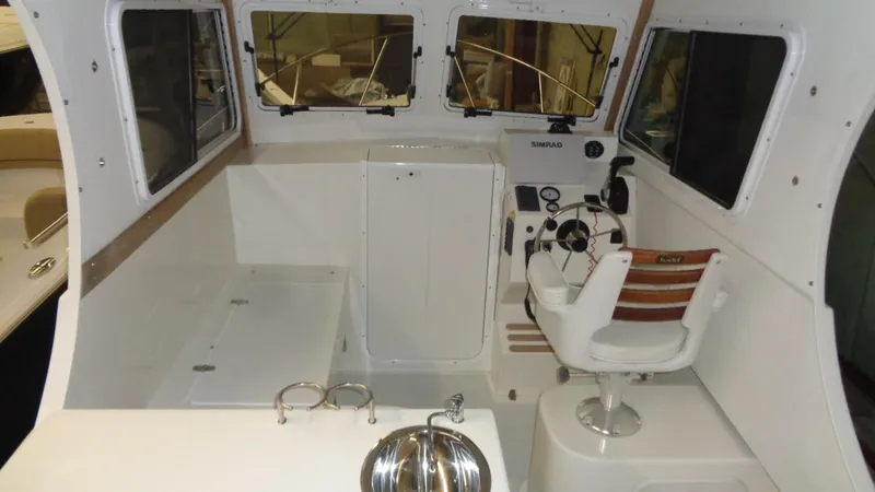 Slide: The Image of 2016 Eastern 248 Explorer boat interior with helm, windows, and seating. - 11