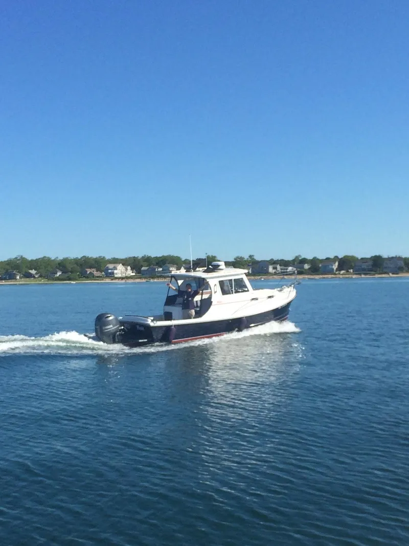 Slide: The Image of 2016 Eastern 248 Explorer boat cruising on calm water under clear blue sky. - 13
