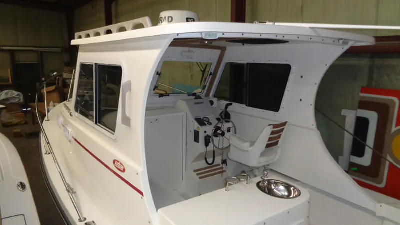 Slide: The Image of 2016 Eastern 248 Explorer boat interior with helm and seating in a storage facility. - 2
