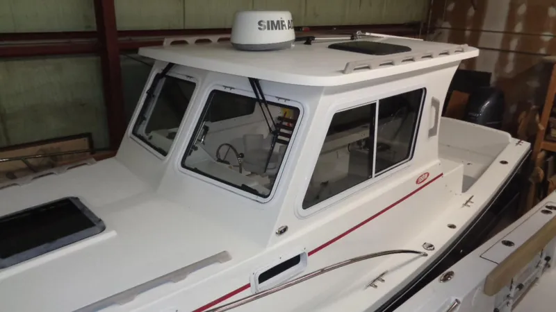 Slide: The Image of 2016 Eastern 248 Explorer boat with enclosed cabin, docked indoors. - 3