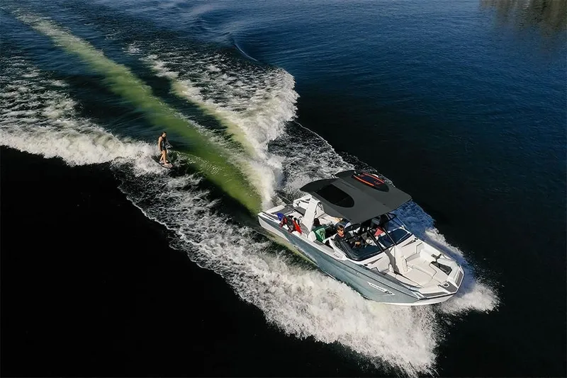 Slide: The Image of 2023 Nautique Super Air Nautique G25 Paragon towing a wakeboarder on a lake. - 11