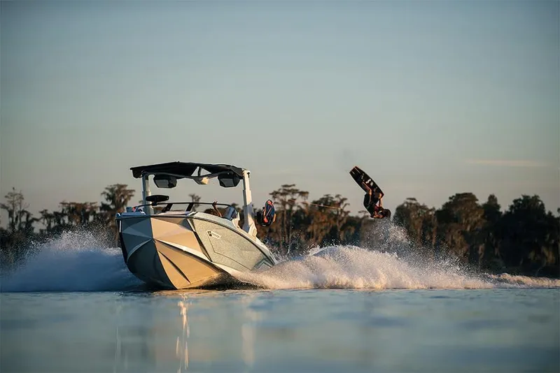 Slide: The Image of 2023 Nautique Super Air Nautique G25 Paragon towing a wakeboarder on a lake. - 12