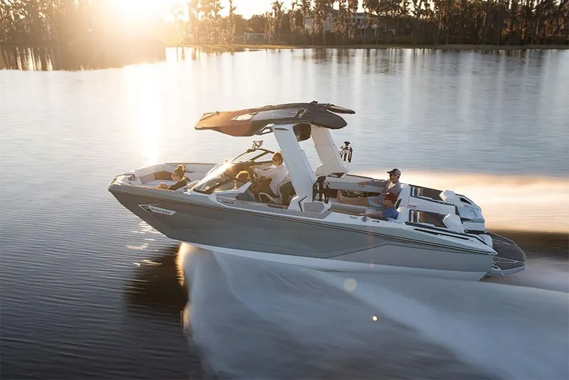 Slide: The Image of 2023 Nautique Super Air Nautique G25 Paragon cruising on a serene lake at sunset. - 4