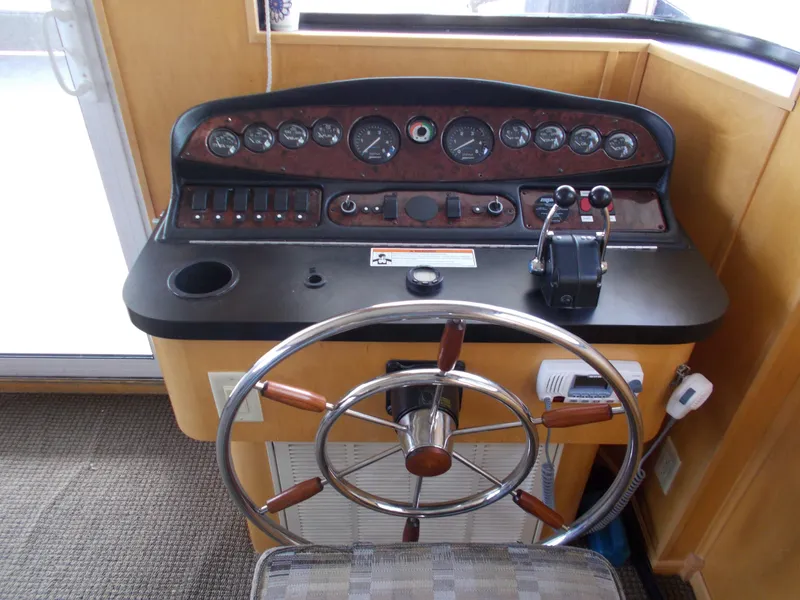 Slide: The Image of 2006 American Waterways Sapphire Skies 1/10 Ownership boat helm with steering wheel and control panel. - 6