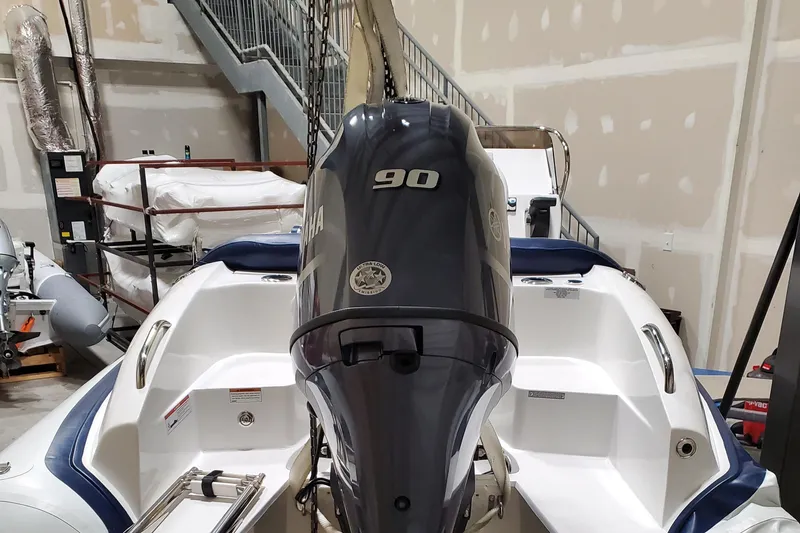 Slide: The Image of 2025 Walker Bay Venture boat with Yamaha 90 engine in a storage facility. - 9