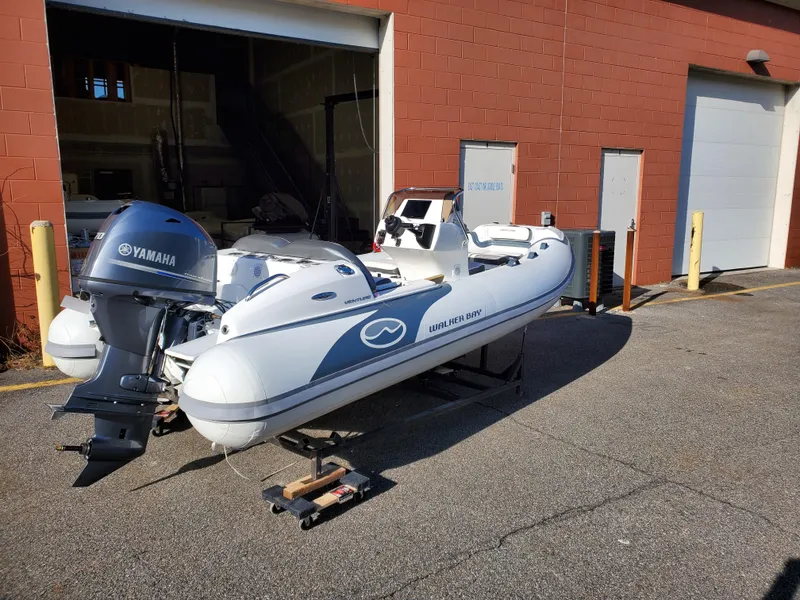 Slide: The Image of 2025 Walker Bay Venture boat with Yamaha outboard motor outside a garage. - 14