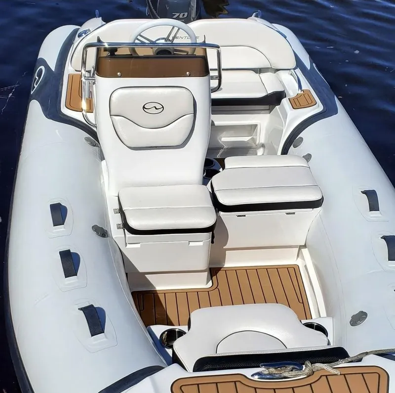 Slide: The Image of 2025 Walker Bay Venture boat with white seating and teak flooring on water. - 7