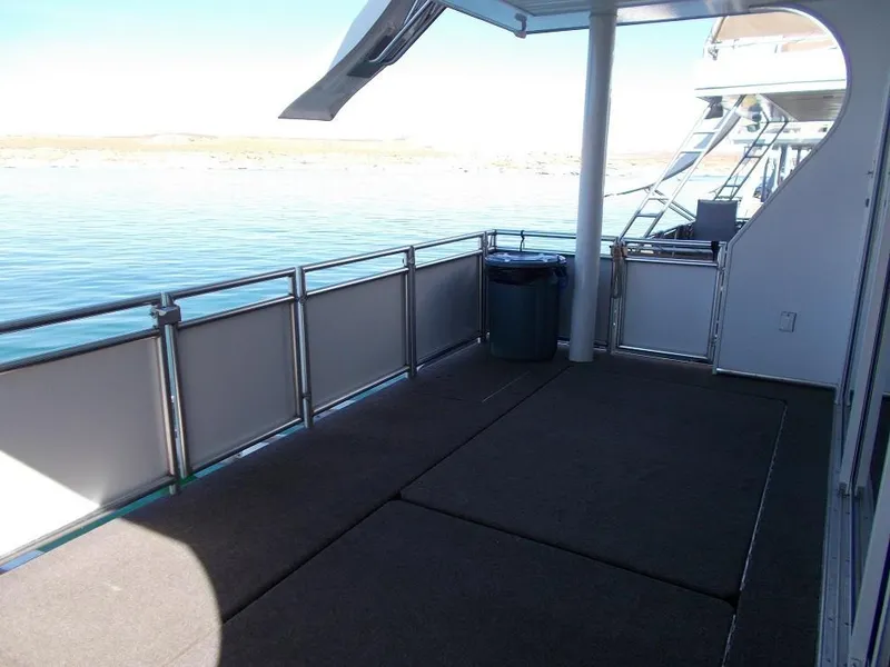 Slide: The Image of Spacious deck of 2015 Bravada Intrepid Trip #1 houseboat on calm water. - 10