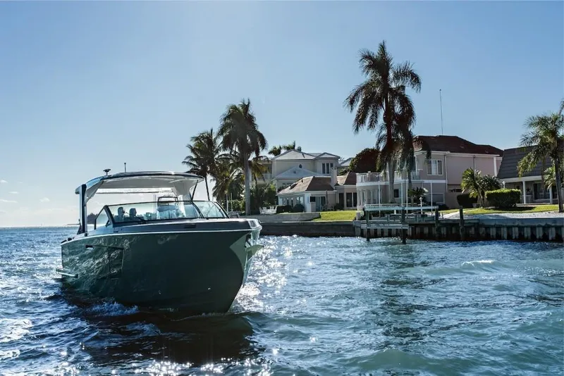 Slide: The Image of 2023 Aviara AV40 boat cruising near waterfront homes with palm trees. - 1