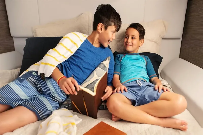Slide: The Image of Two boys relaxing on a 2023 Aviara AV40 boat, enjoying a book. - 13