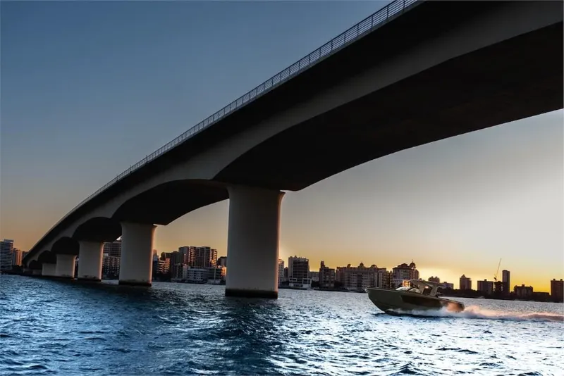 Slide: The Image of 2023 Aviara AV40 boat cruising under a bridge at sunset. - 16