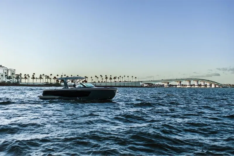 Slide: The Image of 2023 Aviara AV40 boat cruising near a coastal city with a bridge in the background. - 4